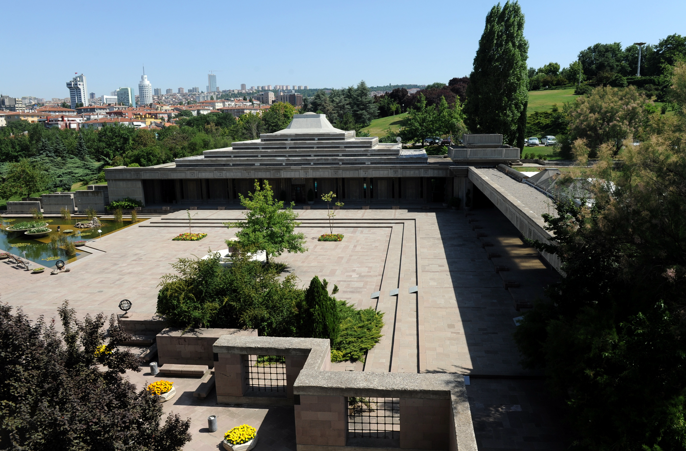 Angular grey building with a water feature to its left.