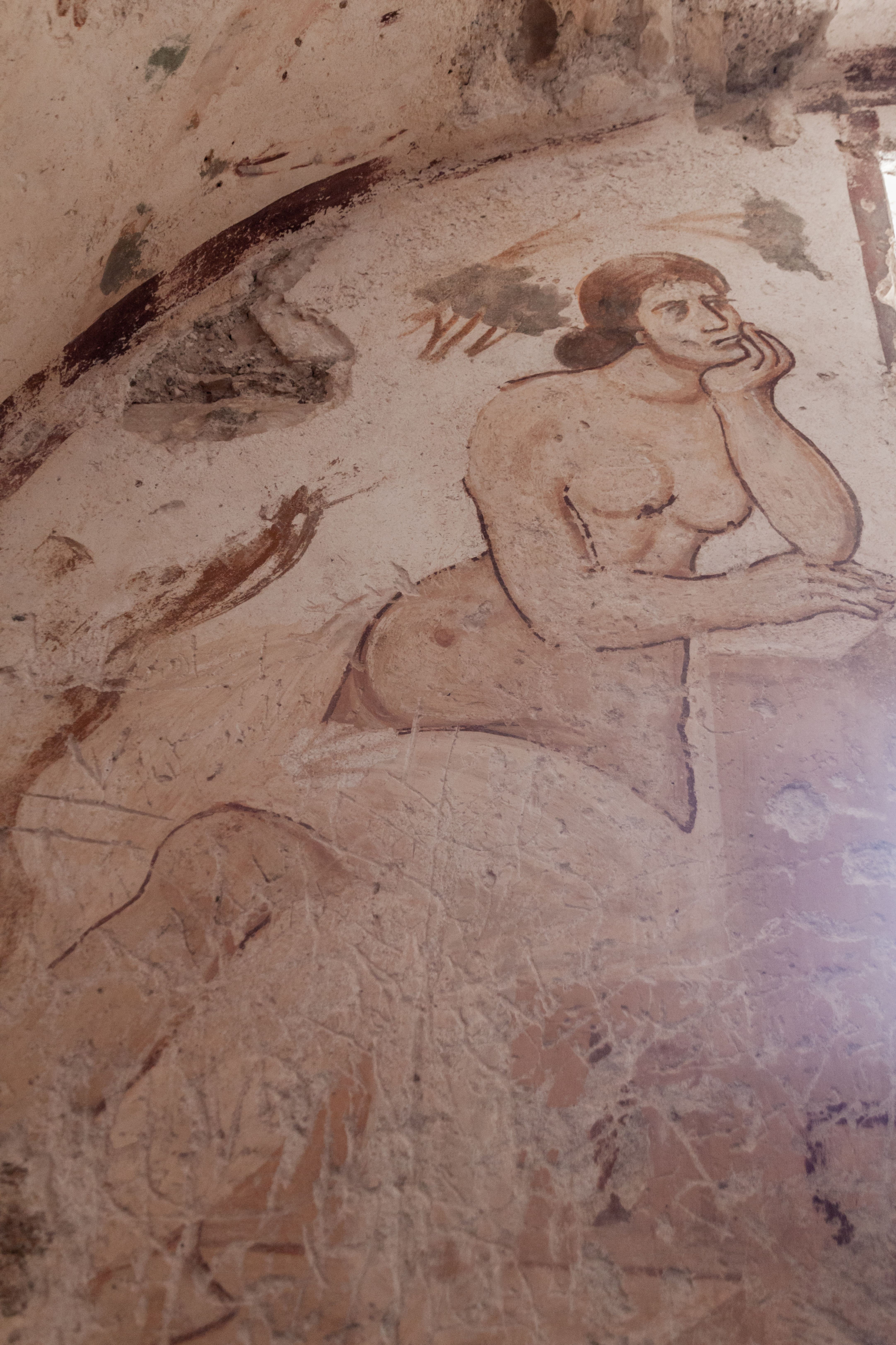 Detail from the fresco showing a shirtless figure leaning on one elbow as if in deep thought.